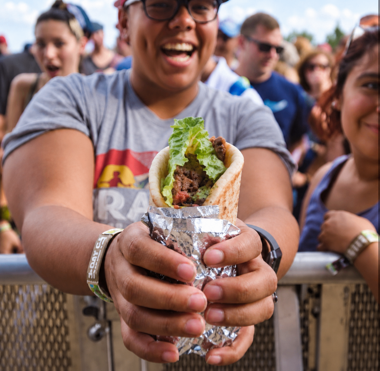 A happy festival guest holding a Lamba's wrap at Zilker Park