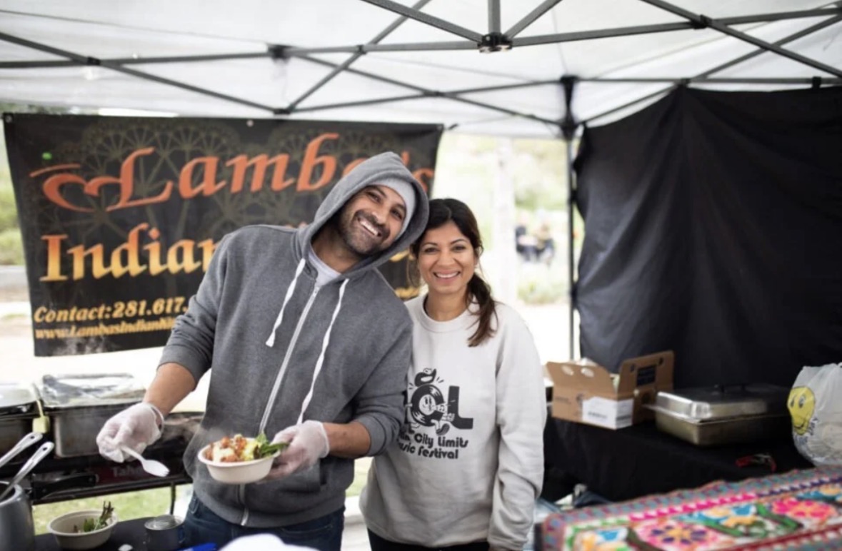 Gurpreet and Garrima serving food at the Lamba's Indian Kitchen market booth